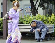 日本，一名妇女路过无家可归者。亚洲的高增长减少了贫困，但也伴随着日益严重的不平等。（图片: Corbis/Haruyoshi Yamaguchi） 